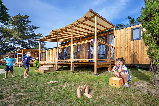 Mobil-homes en bois et enfants jouant au camping CLICOCHIC Longchamp à Saint Lunaire (35). Mobil-homes en bois et enfants jouant au camping CLICOCHIC Longchamp à Saint Lunaire (35).
